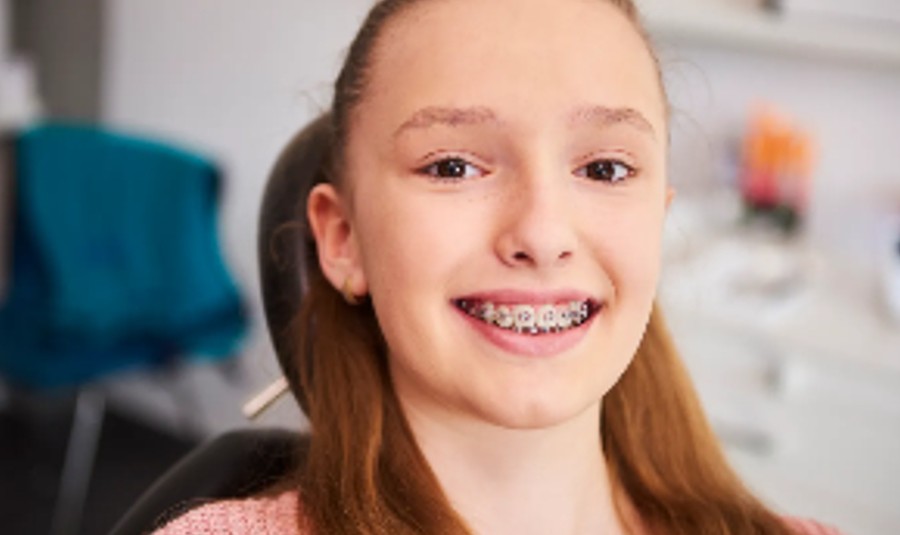 Jovem sorrindo com aparelho ortodôntico